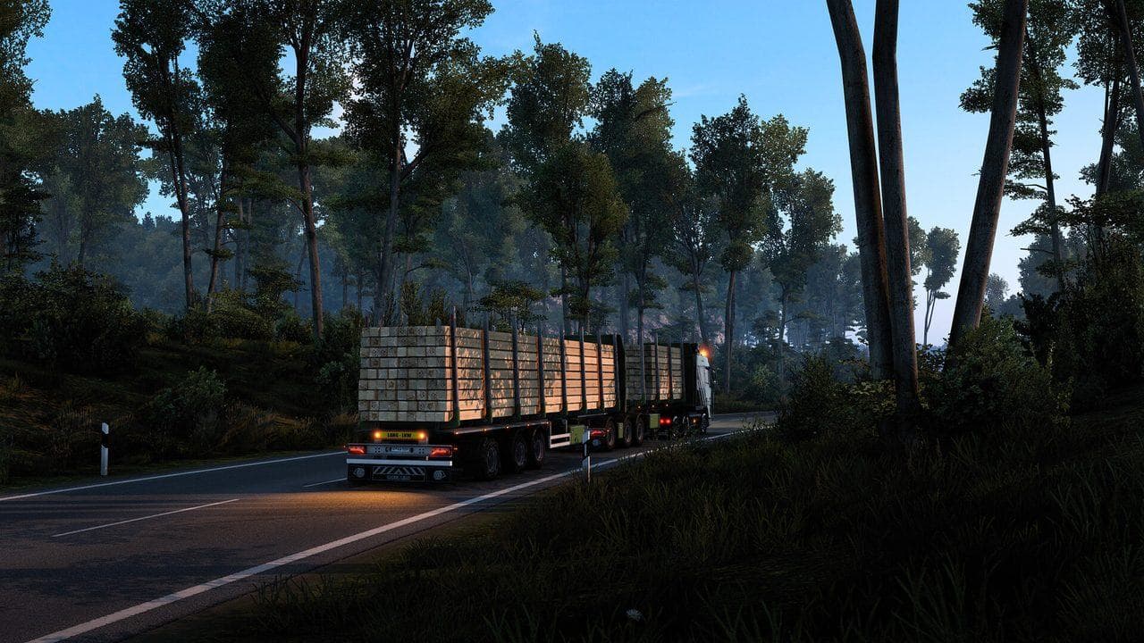 Euro Truck Simulator 2 timber trailer driving through a forest road at dusk